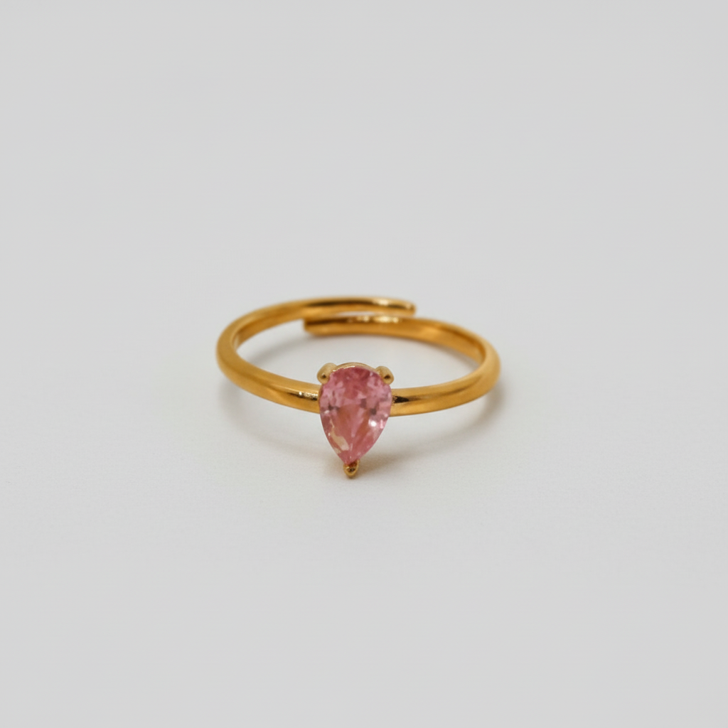ATORI Lumini gold plated adjustable ring with a teardrop-shaped pink stone on top.
