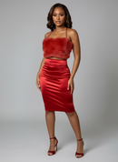 Woman wearing a red fur top and red skirt on a gray background