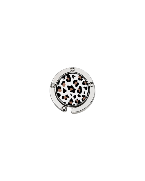 ATORI Unbothered circular silver-toned metal handbag hook accessory with a leopard print design, shown on a plain white background.